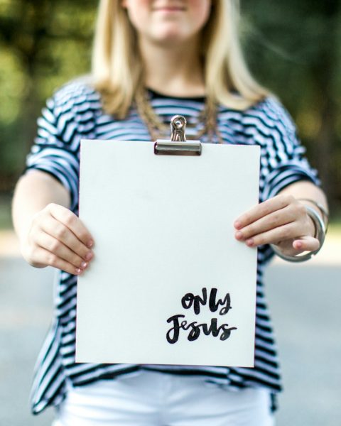 woman in blue and white long sleeve shirt holding white book