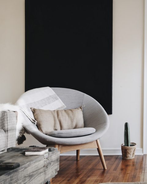 round grey moon chair with brown pillow on top