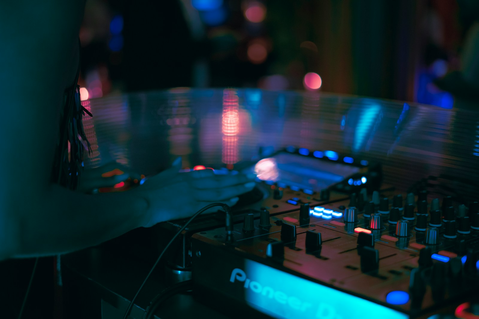 a dj mixing a track in a dark room