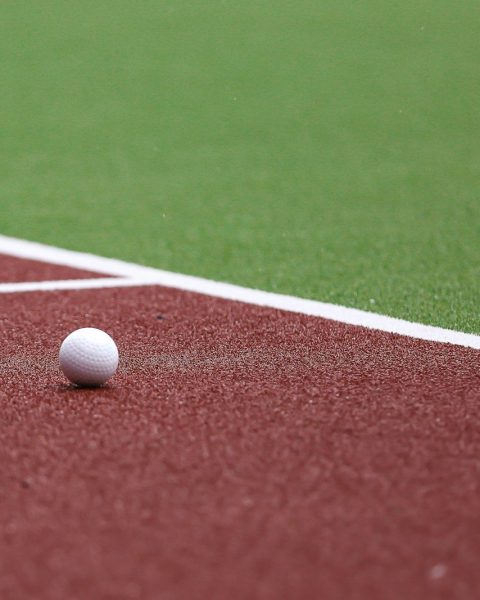 a golf ball on a red field