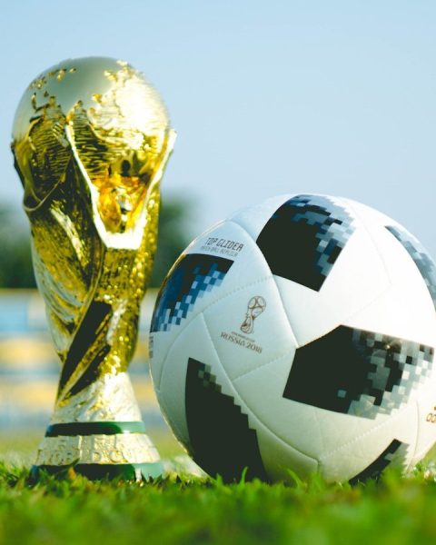 gold-colored trophy and soccerball