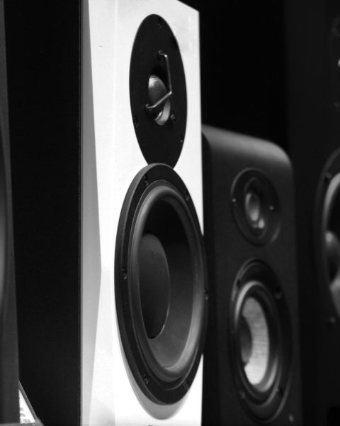 black and gray speakers on brown wooden table
