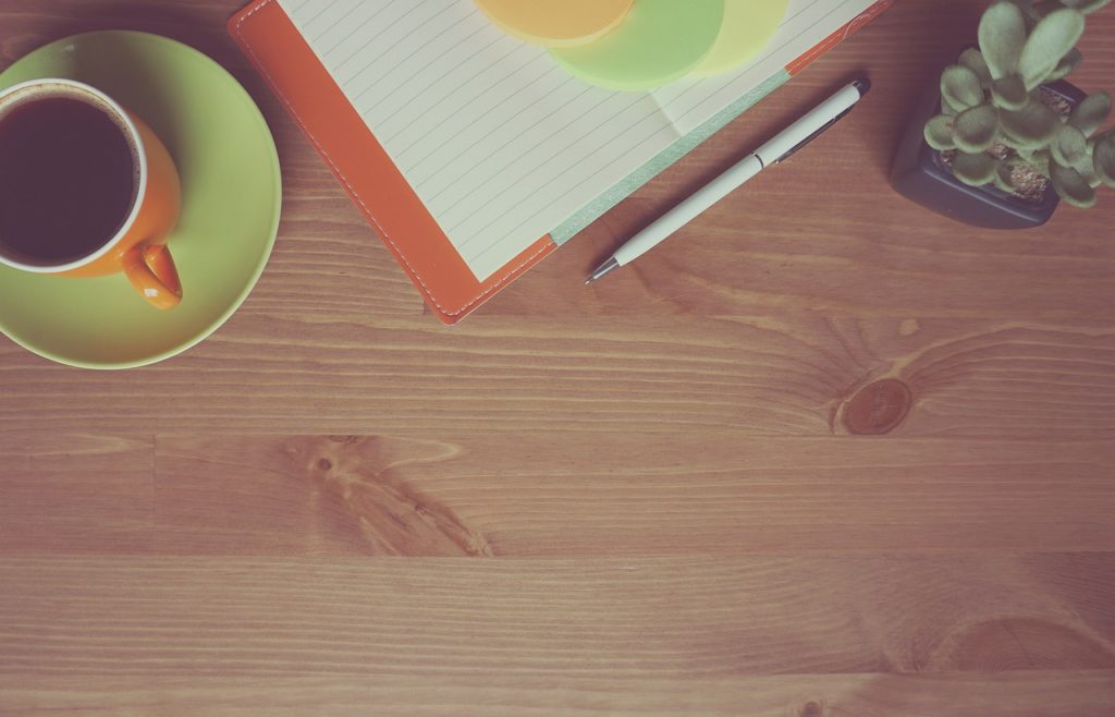 Een groene kamerplant op een houten bureau in een modern appartement