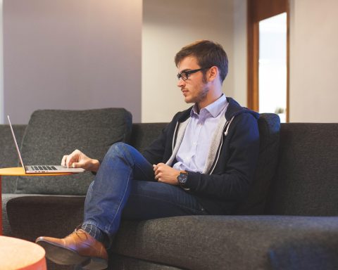 Jonge man werkt op laptop in een modern kantoor