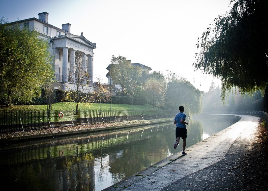 Jonge man die vroeg in de ochtend buiten loopt in de zomer