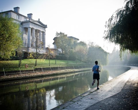 Jonge man die vroeg in de ochtend buiten loopt in de zomer