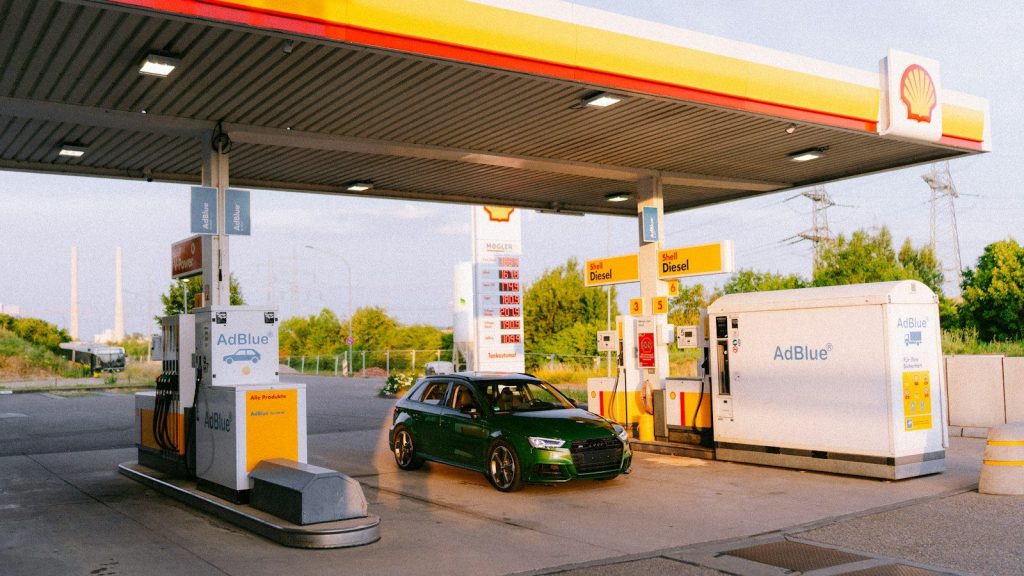 A green car parked at a shell gas station