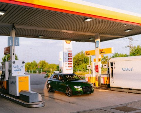 A green car parked at a shell gas station