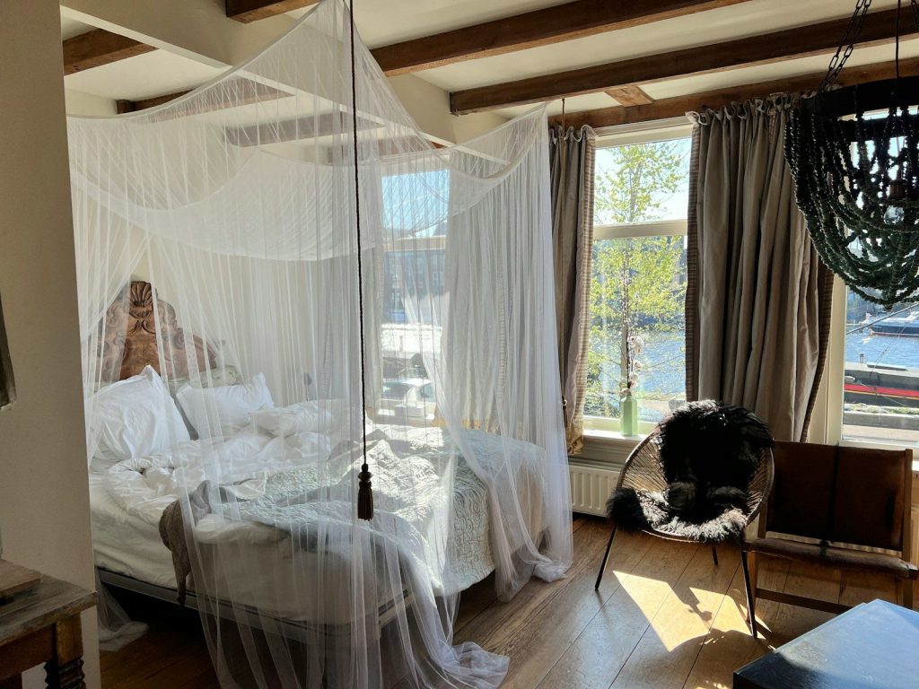 a bedroom with a canopy bed and a chair