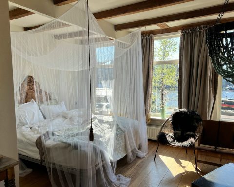 a bedroom with a canopy bed and a chair