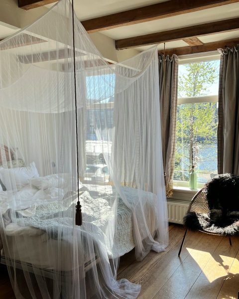 a bedroom with a canopy bed and a chair