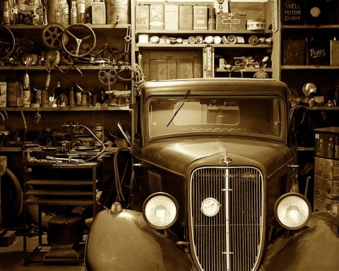 Monteur inspecteert een klassieke auto in een garage