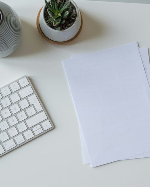 white printer paper beside white apple keyboard