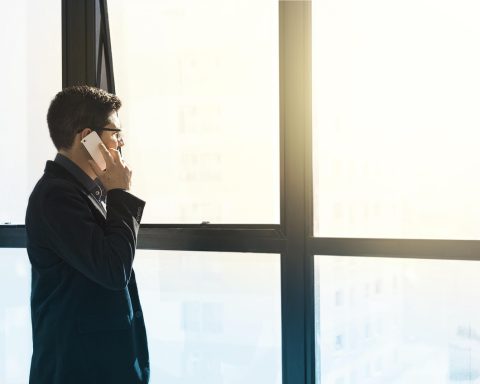 Jonge man bekijkt zijn financiën en salarisbonnetjes aan zijn bureau